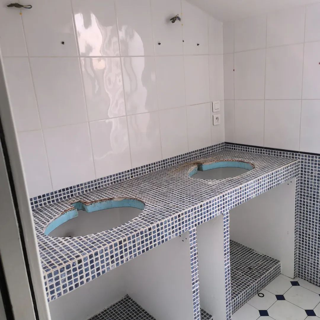 Salle de bains avec un comptoir et un mur carrelés.