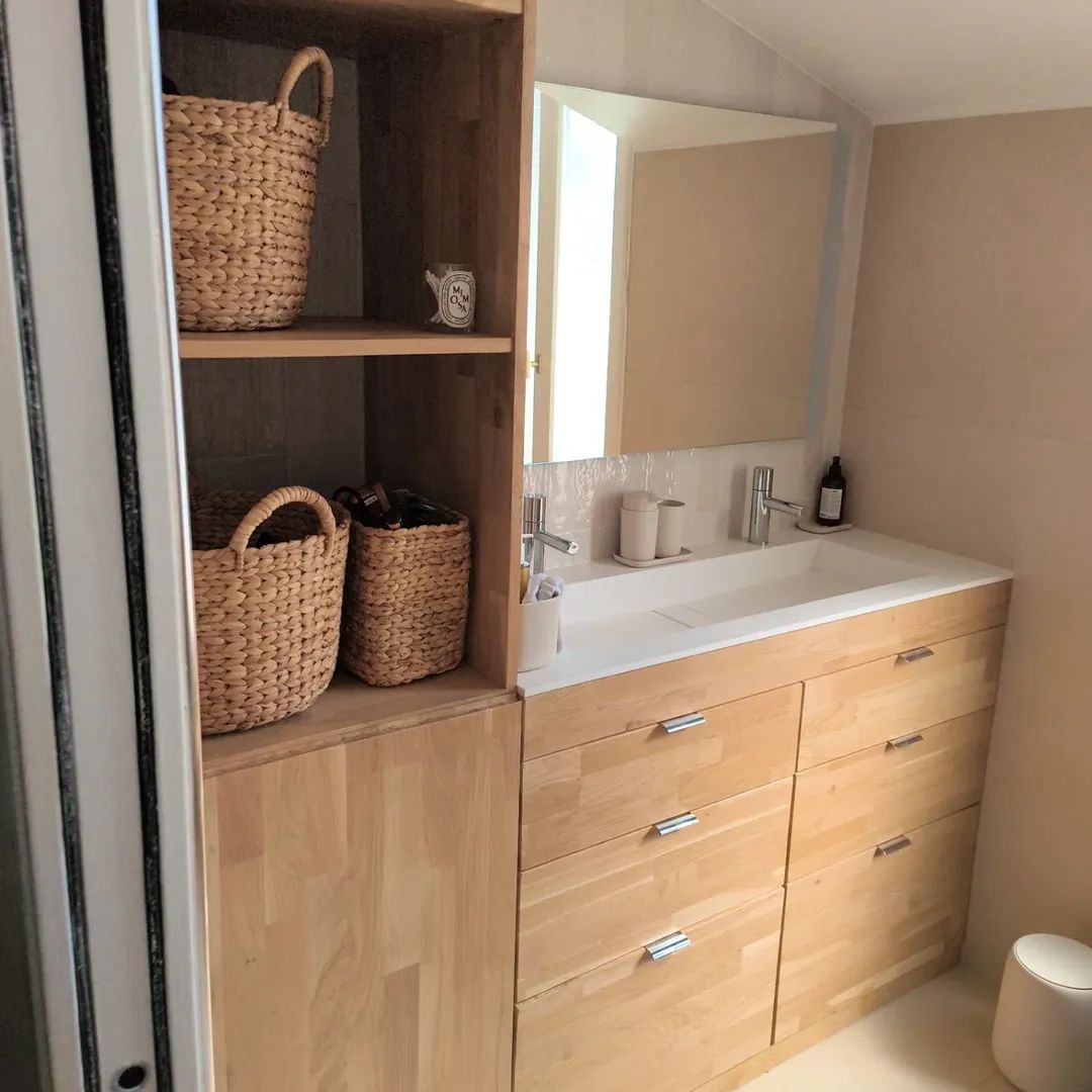 Salle de bains avec un meuble vasque en bois.