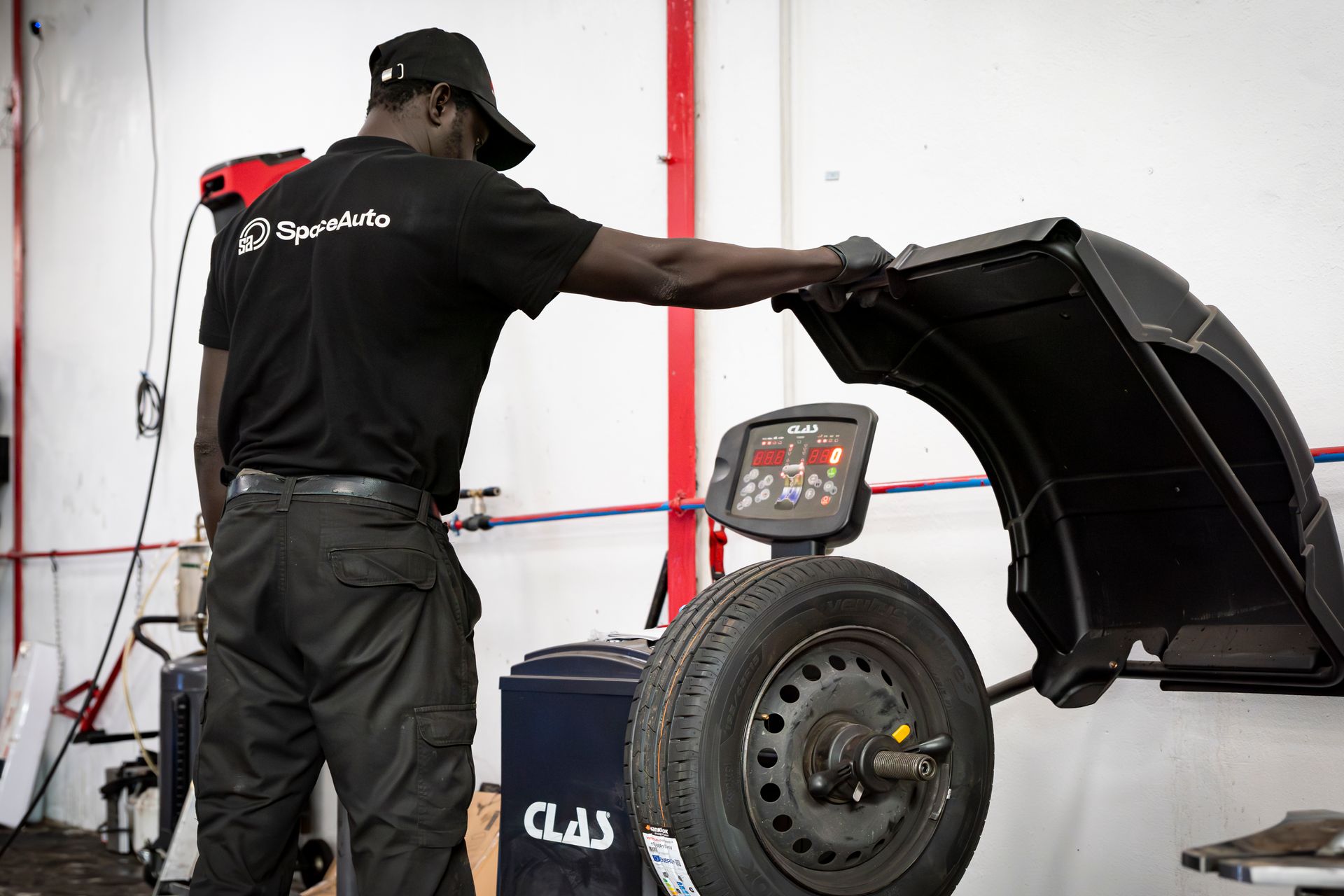 Garagiste qui équilibre des pneus avec une machine