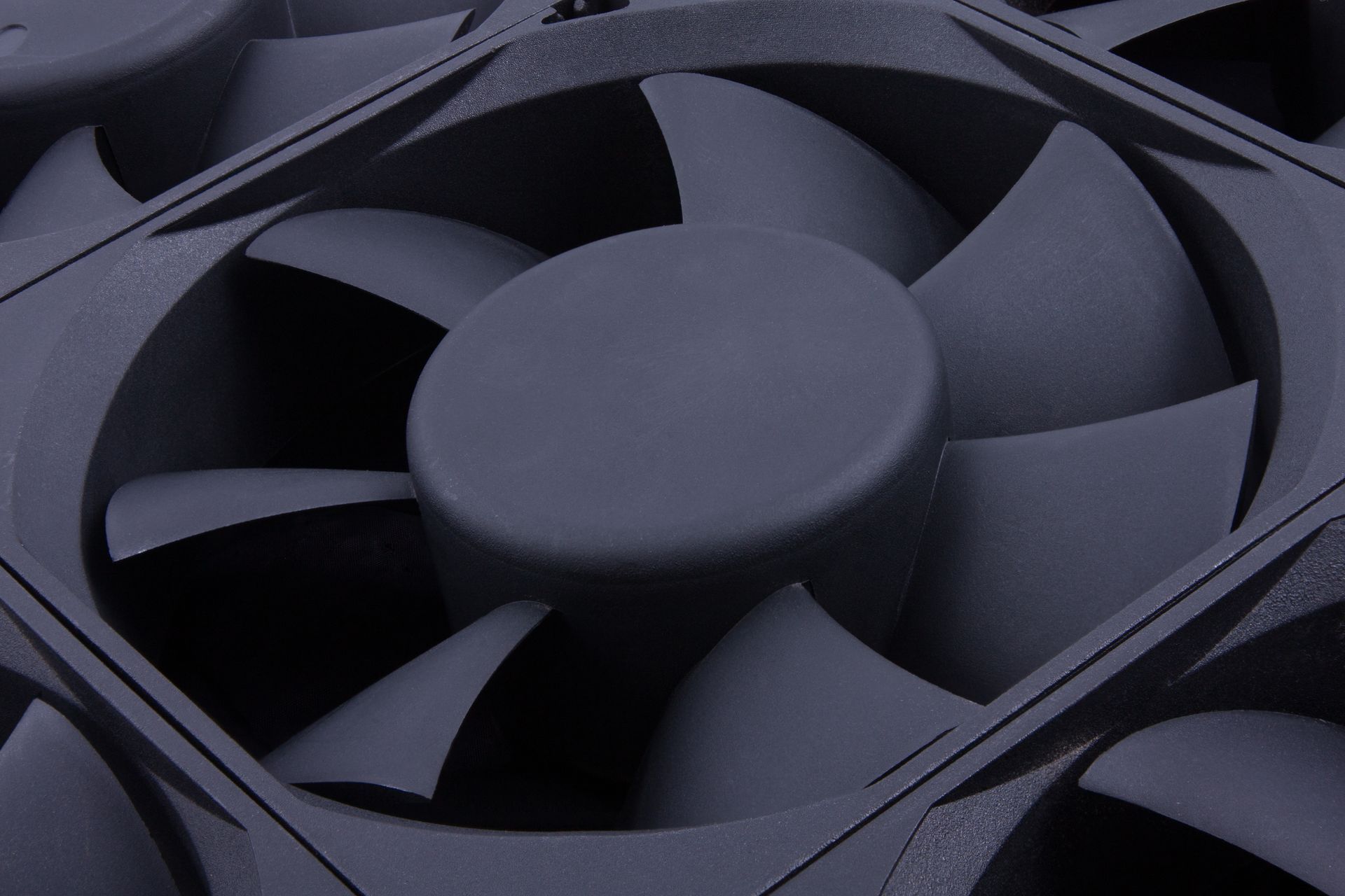 Gros plan sur un ventilateur de refroidissement noir avec des pales en rotation à l'intérieur d'un ordinateur ou d'un appareil électronique.
