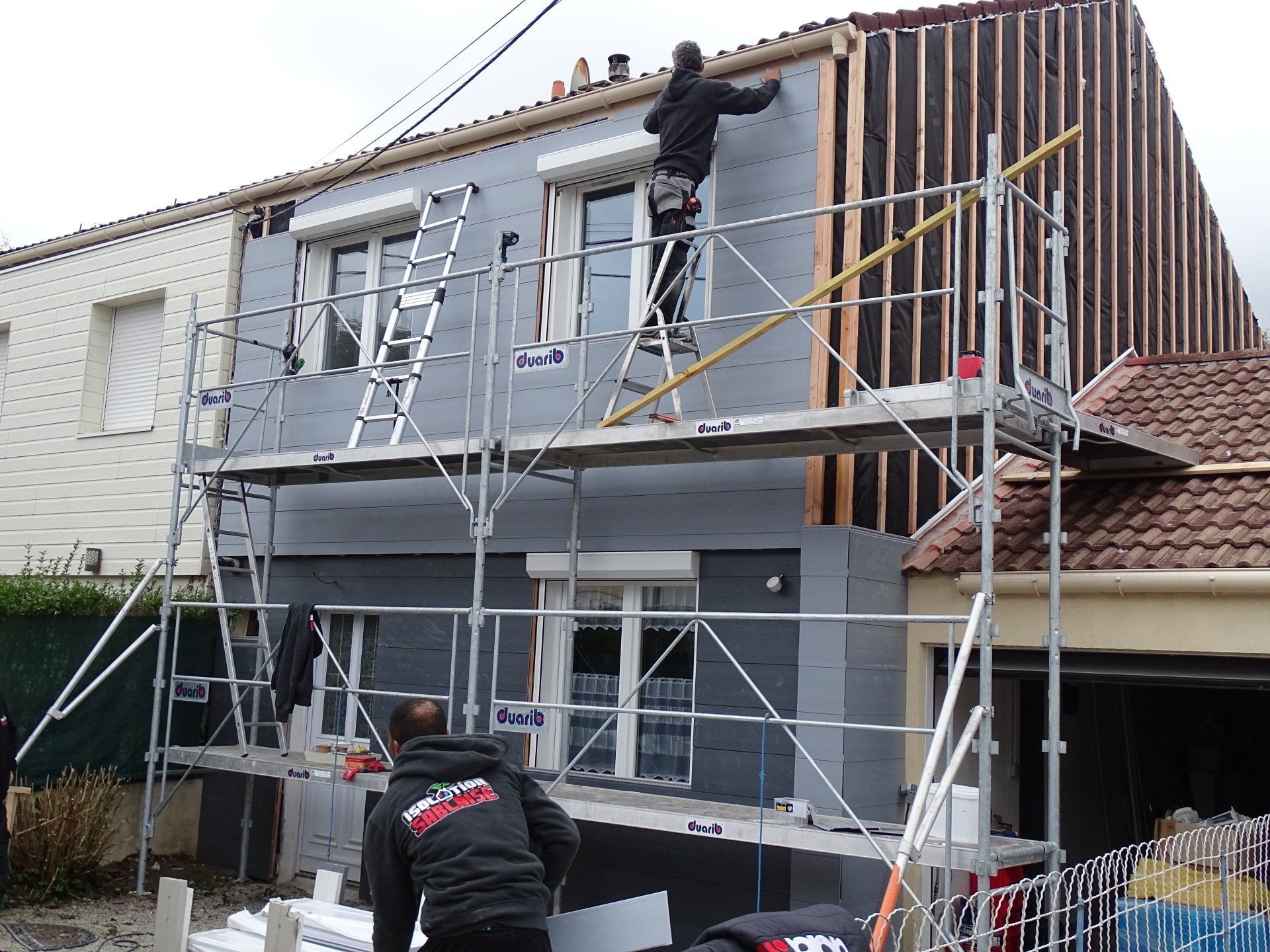 Un ravalement de façade avec deux artisans en action
