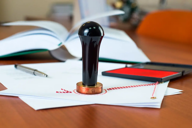Un sello está encima de un trozo de papel sobre una mesa.