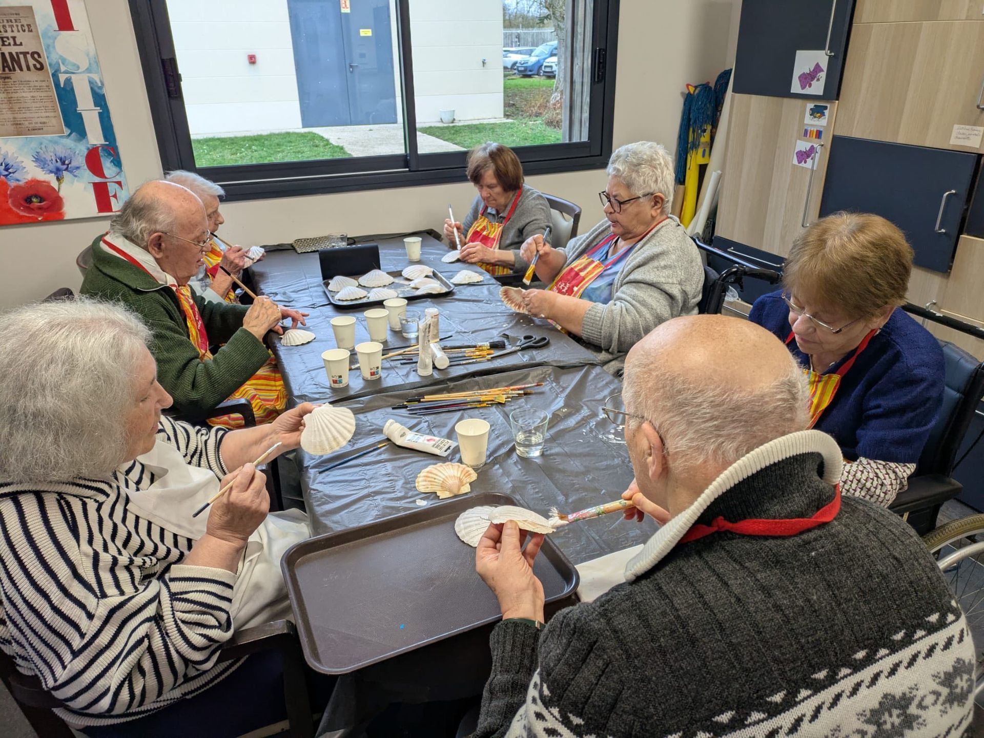 Un groupe de personnes âgées déjeunent ensemble à une table dans une salle commune