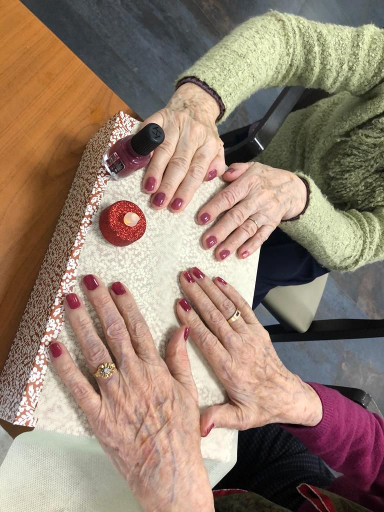 Des mains tiennent un objet blanc texturé avec des boutons rouges et un bouton noir sur une table