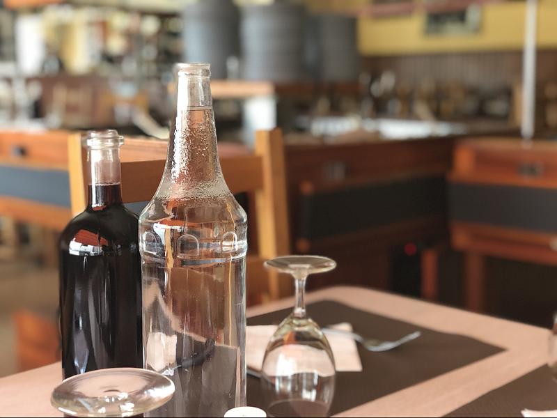 Bouteilles et verre à pied sur une table de restaurant