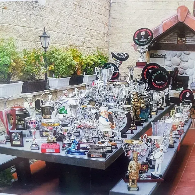 Un montón de trofeos sobre una mesa con uno que dice