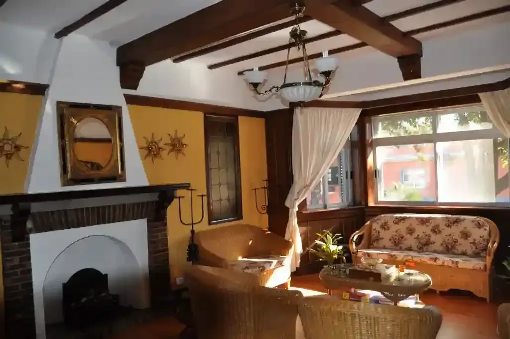Una sala de estar con chimenea, sofá y sillas.