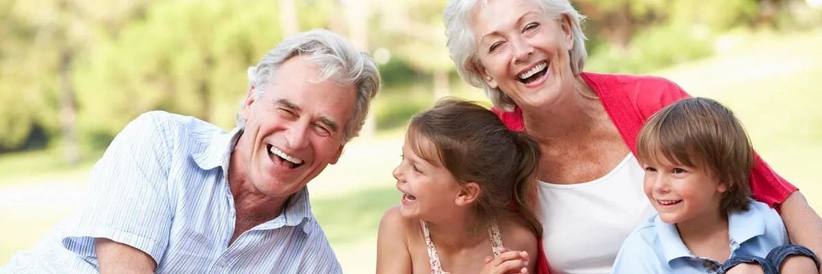 Una familia posa para una foto en un parque y sonríe.