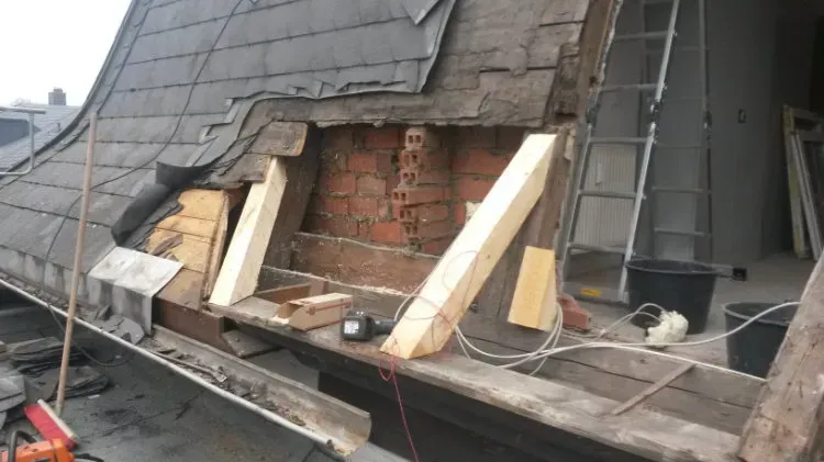 Zimmerei Andreas Karl GmbH - freigelegte Holzbalken unter einem verwitterten Dach