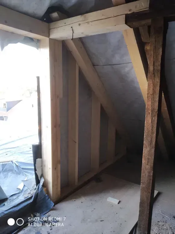 Zimmerei Andreas Karl GmbH - Foto von der Ecke eines Dachgeschosses, freigelegte Dachbalken