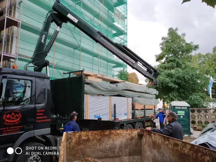 Zimmerei Andreas Karl GmbH - mehrere Personen vor einem LKW mit Holzbauteilen