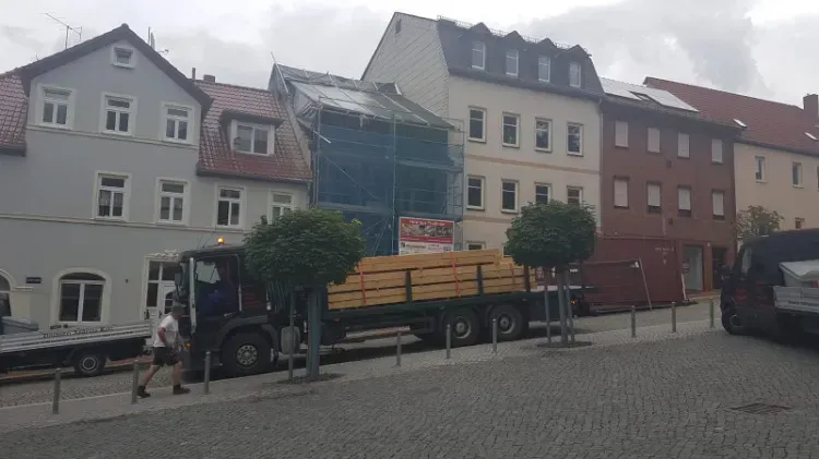 Zimmerei Andreas Karl GmbH - Transport-LKW mit Holzbauteilen vor einem Reihenhaus während einer Altbausanierung