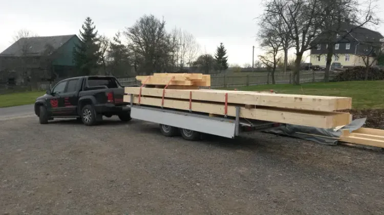 Zimmerei Andreas Karl GmbH - Pickup-Truck mit Anhänger, beladen mit sperrigen Holzbalken