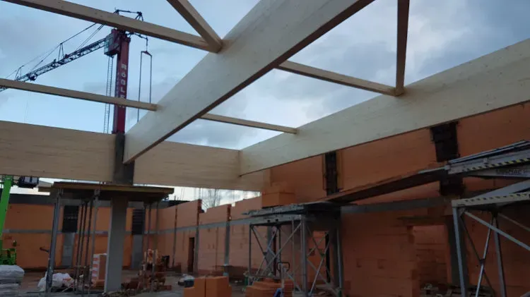 Zimmerei Andreas Karl GmbH - Blick auf Holzbalken als Dachkonstruktion über einem Rohbau