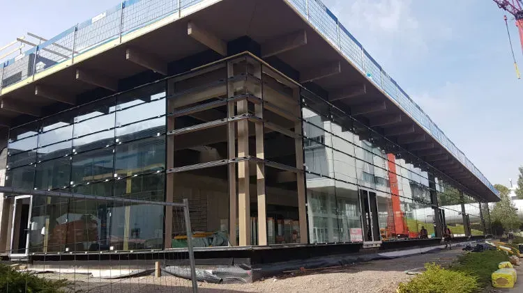 Zimmerei Andreas Karl GmbH - Gebäude im Bau, bestehend aus Holzkonstruktion und Glasfassade