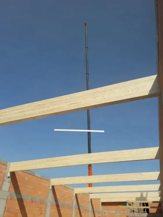 Zimmerei Andreas Karl GmbH - Holzbalken eines Schrägdaches vor einem blauen Himmel