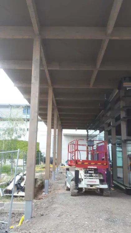 Zimmerei Andreas Karl GmbH - vertikale Holzbalken als Stützelemente für ein Vordach aus Holz