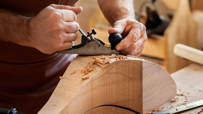 Zimmerei Andreas Karl GmbH - Mann sägt Holzplatte