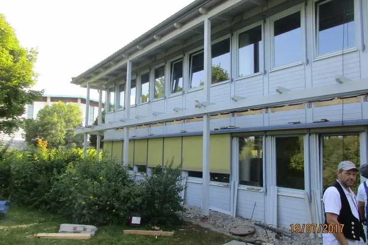 Zimmerei Andreas Karl GmbH - altes Gebäude mit weiß gestrichener Holzkonstruktion als Fassade