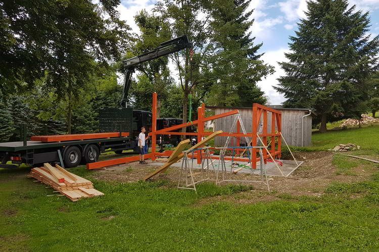Zimmerei Andreas Karl GmbH - Gerüstteile für ein Gartenhäuschen im Bau auf grüner Wiese