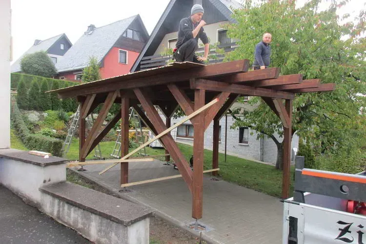 Zimmerei Andreas Karl GmbH - Zwei Arbeiter auf einem Holzgerüst eines Carports vor der Eindeckung