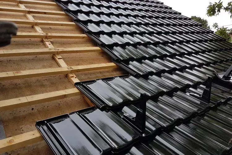 Zimmerei Andreas Karl GmbH - Ansicht eines teilweise sanierten Daches mit Holzbalken