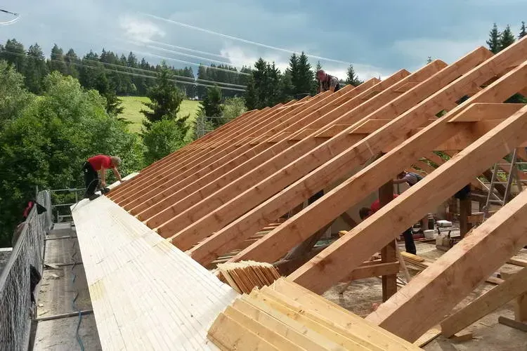 Zimmerei Andreas Karl GmbH - Mann auf Dach, offene Dachkonstruktion
