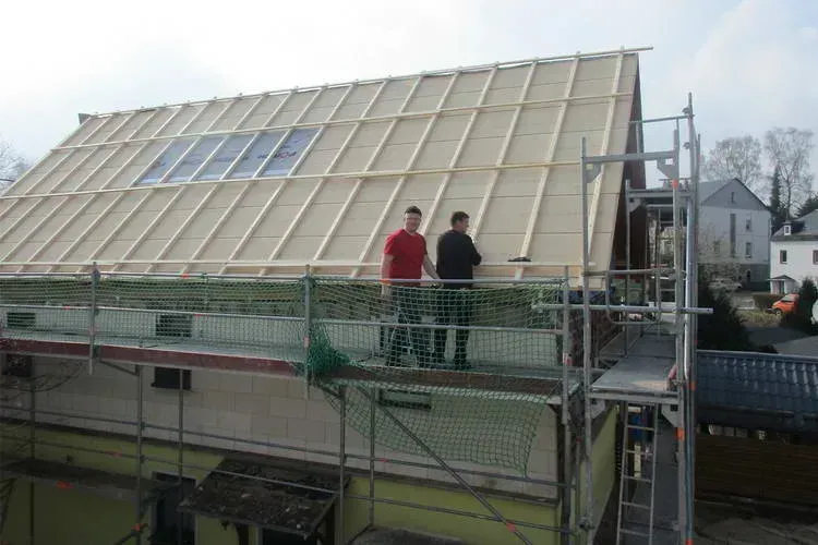 Zimmerei Andreas Karl GmbH - Zwei Männer auf einem Gerüst an einem Dach im Bau