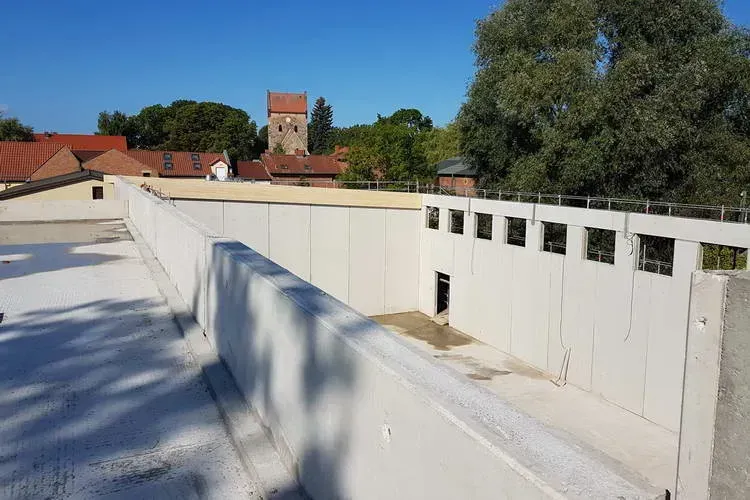 Zimmerei Andreas Karl GmbH - Betonwände, Stadt im Hintergrund, blauer Himmel