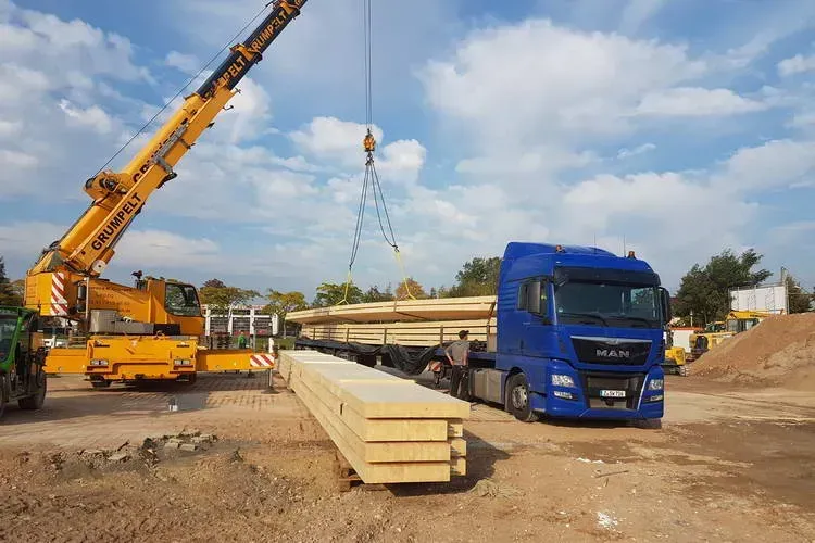 Zimmerei Andreas Karl GmbH - Baukran und LKW, Stapel mit schweren Holzbalken für Holzbau