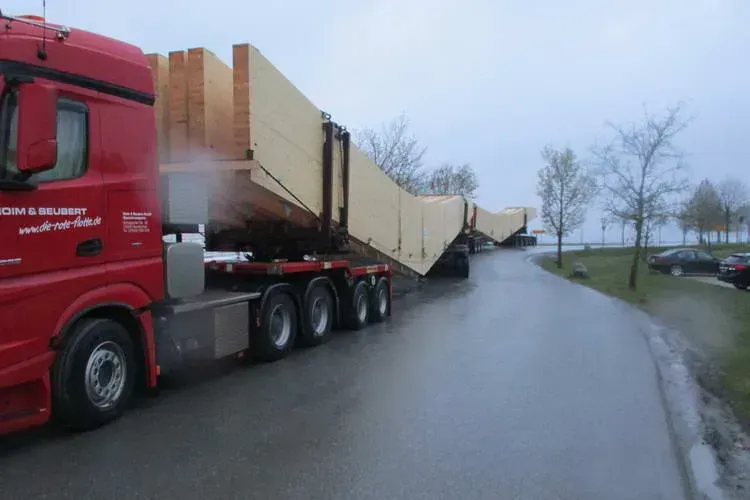 Zimmerei Andreas Karl GmbH - Überlanger LKW transportiert lange Holzbauteile für Dachkonstruktion