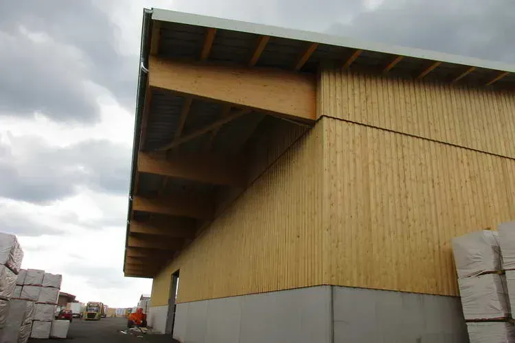 Zimmerei Andreas Karl GmbH - Holzgebäude mit Vordach, bewölkter Himmel