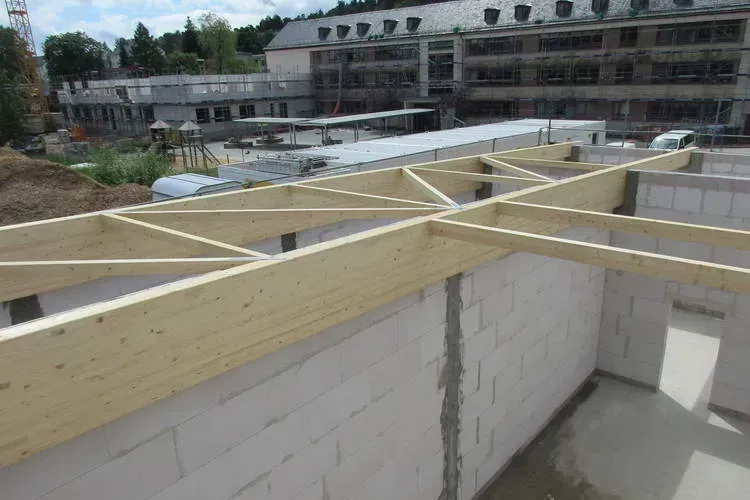 Zimmerei Andreas Karl GmbH - Holzstreben auf einer Steinwand als Träger für Querbalken