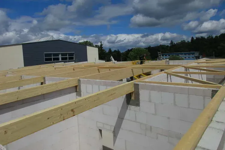 Zimmerei Andreas Karl GmbH - Rohbau eines Gebäudes mit Holzbalken auf den Wänden