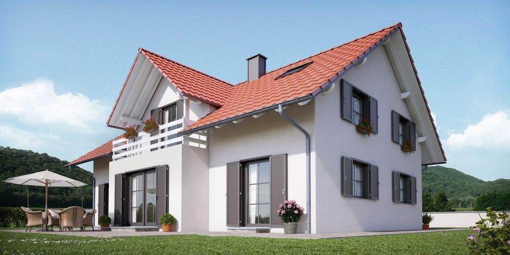 Una casa bianca con il tetto rosso si trova in cima a un rigoglioso campo verde.