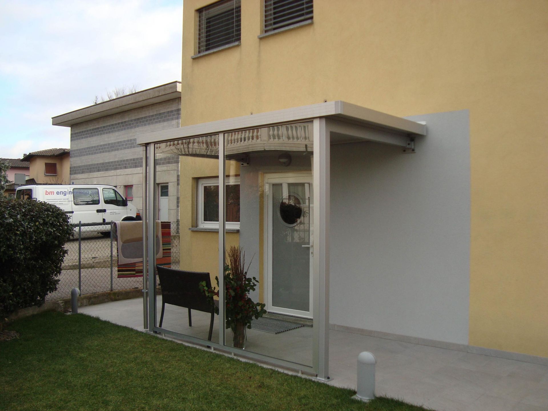 Una casa gialla con un furgone bianco parcheggiato davanti