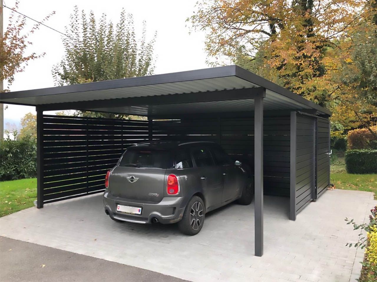 Un'auto è parcheggiata sotto una tettoia in un posto auto coperto.