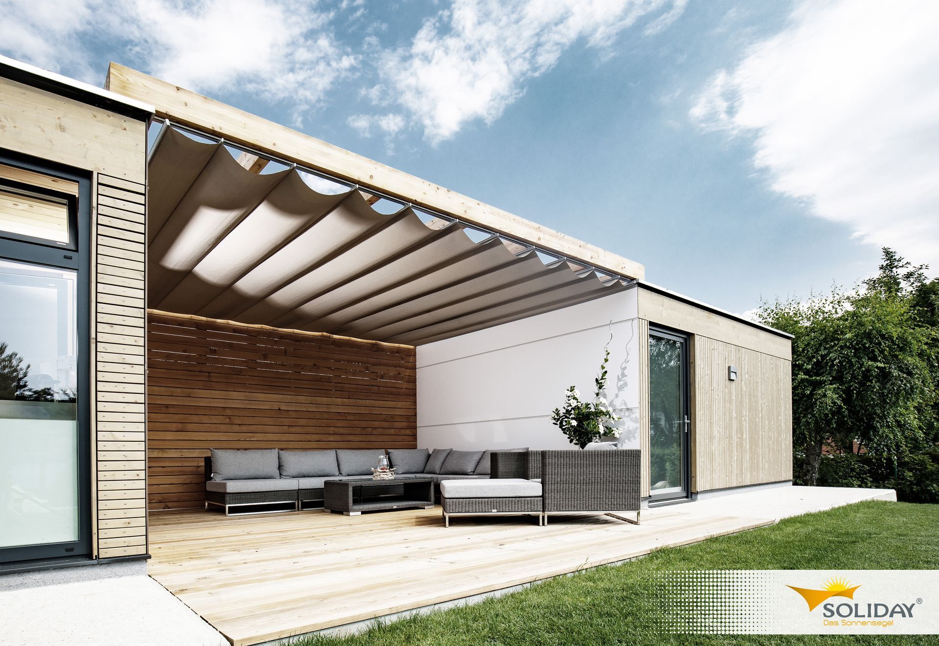 Un patio con un divano e un tavolo sotto una tettoia