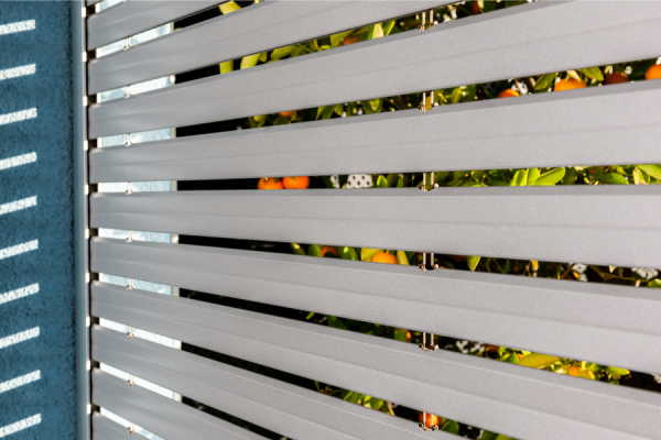 Un primo piano di una recinzione bianca con un muro blu sullo sfondo.