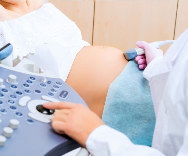 Una mujer embarazada se está haciendo una ecografía con un médico.