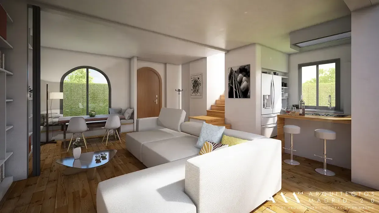 Moderna sala de estar con sofá blanco, cocina y ventana arqueada con vista a la vegetación.