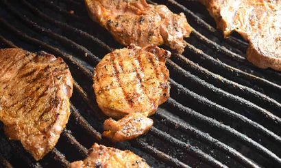 Auf einem Grill wird eine Menge Fleisch gegart.