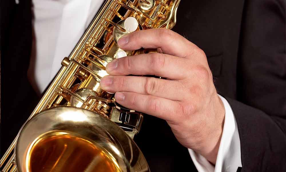 Ein Mann im Smoking spielt Saxophon.