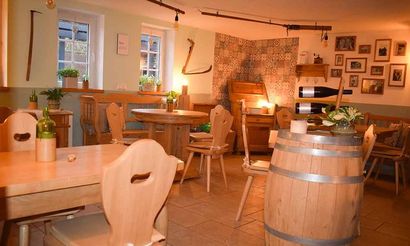 Ein Restaurant mit Holztischen und -stühlen und Holzfässern.