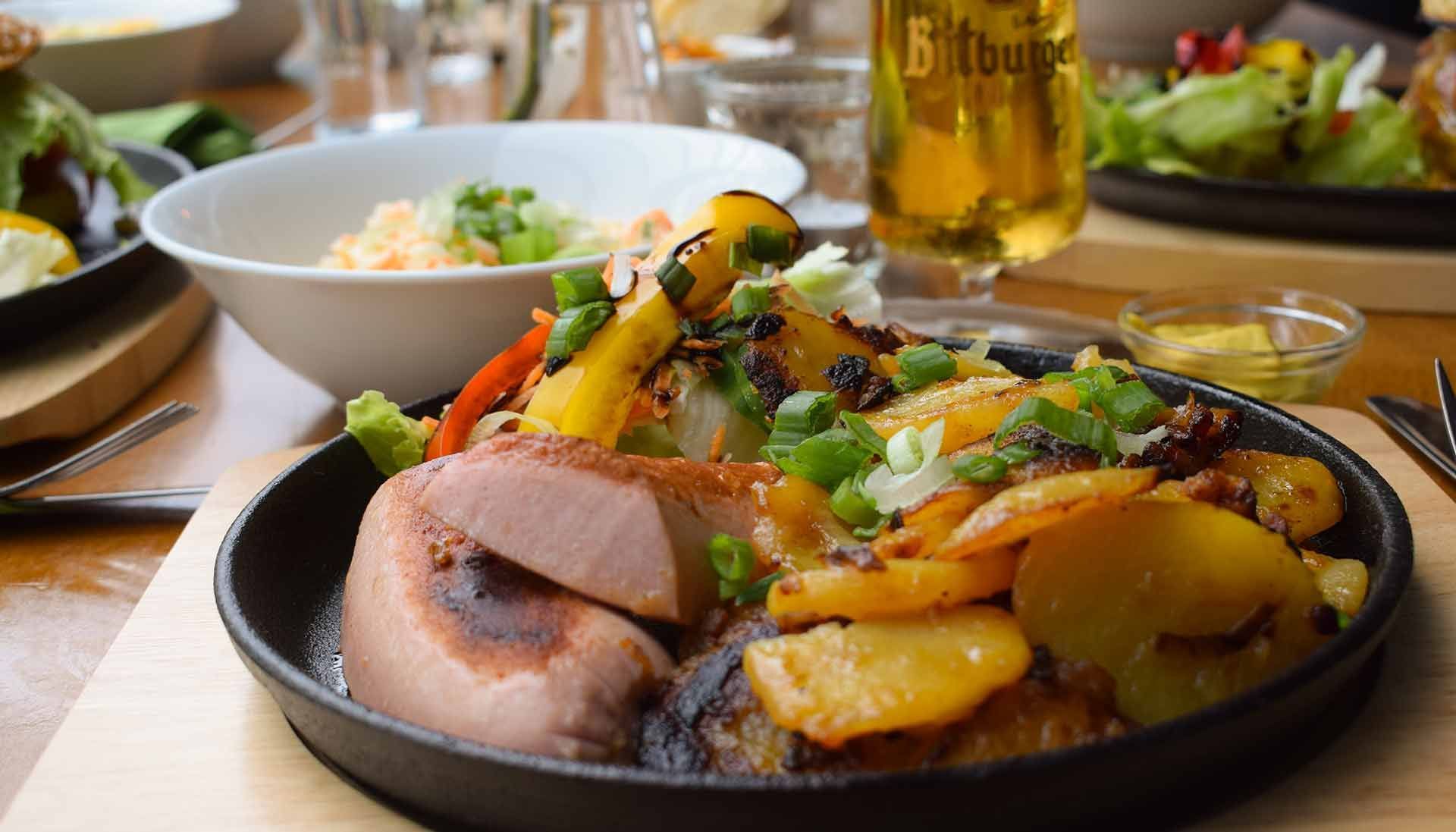 Ein Teller mit Fleisch und Kartoffeln auf einem Tisch.