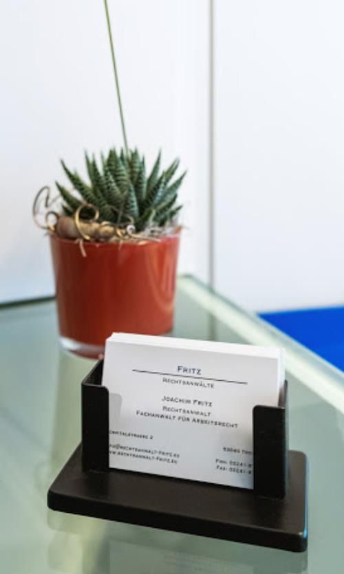 Ein Visitenkartenhalter mit einer Pflanze im Hintergrund