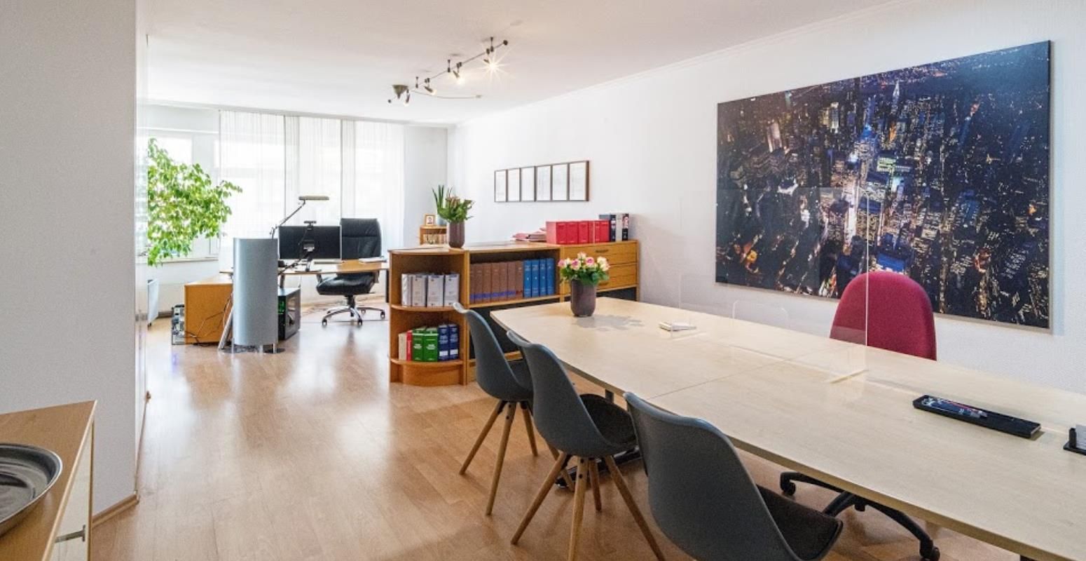 Ein Konferenzraum mit einem langen Tisch und Stühlen