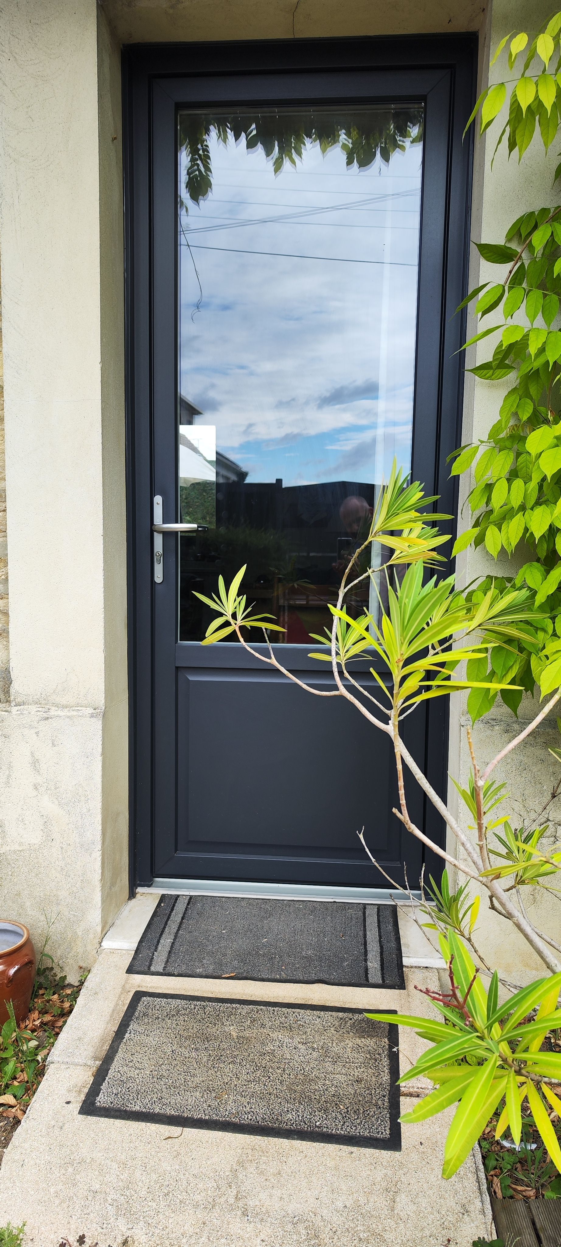 Une porte d'entrée vitrée de couleur grise