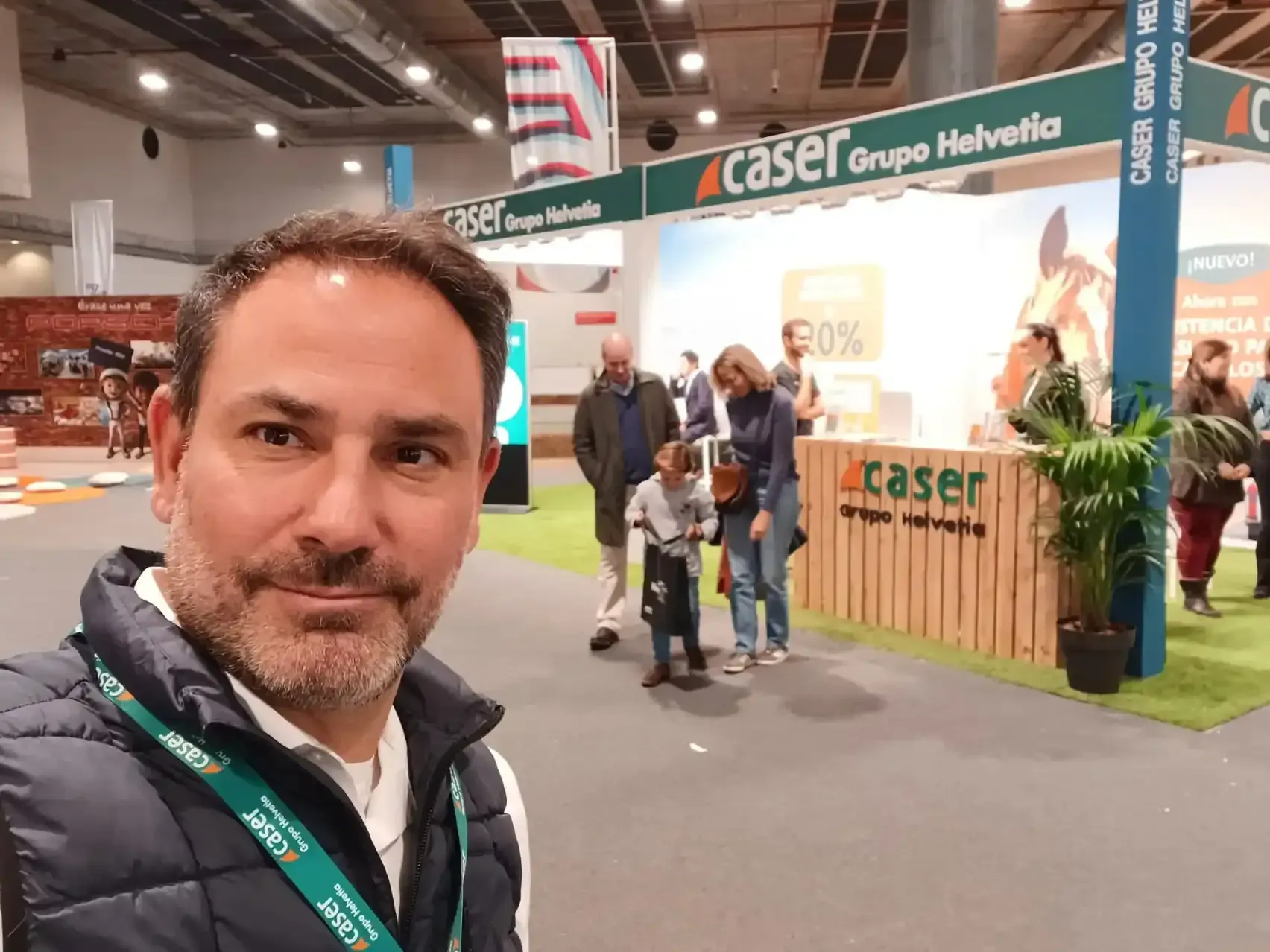 Ricardo, Agente Caser tomándose un selfie en un stand de Caser Grupo Helvetia en una feria comercial.