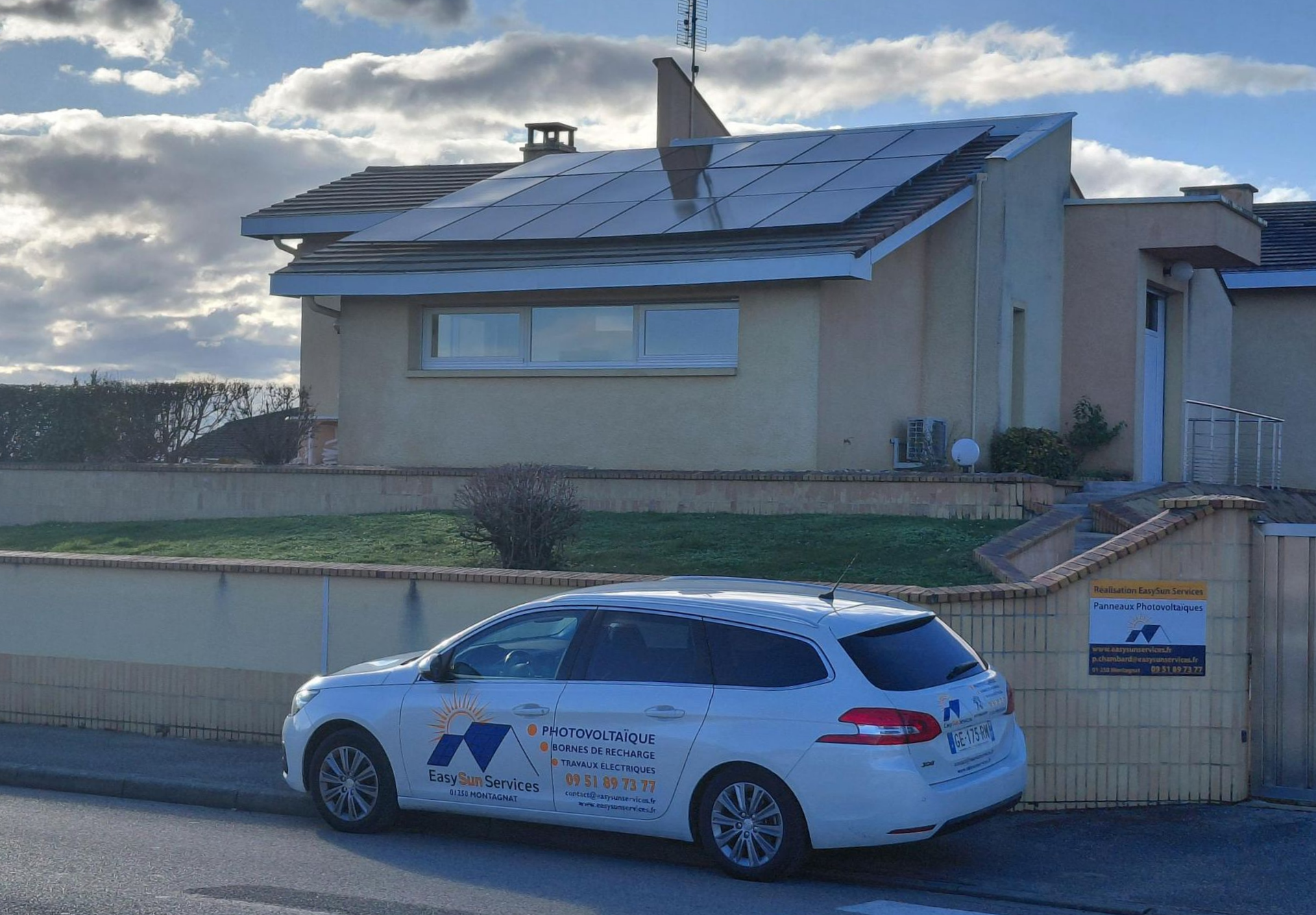 Maison avec une voiture de l'entreprise garée dans la rue.